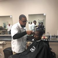 A man is getting his hair cut at a barber shop.