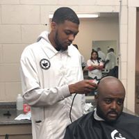 A man is getting his hair cut by a barber in a barber shop.