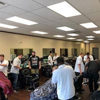 A group of men are getting their hair cut at a barber shop.