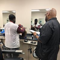 A man is getting his hair cut by a barber in a barber shop.