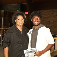 A man and a woman are posing for a picture while holding a certificate.