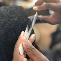 A person is cutting a person 's hair with a pair of scissors.