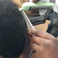 A man is getting his hair cut at a barber shop.