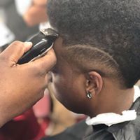 A man is getting his hair cut by a barber.