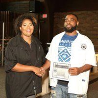 A man and a woman are shaking hands in a room.