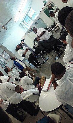 A group of people are sitting around tables in a room.