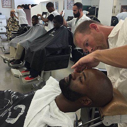 A man is getting his hair cut at a barber shop