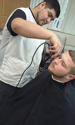 A man is getting his hair cut by a barber in a barber shop.