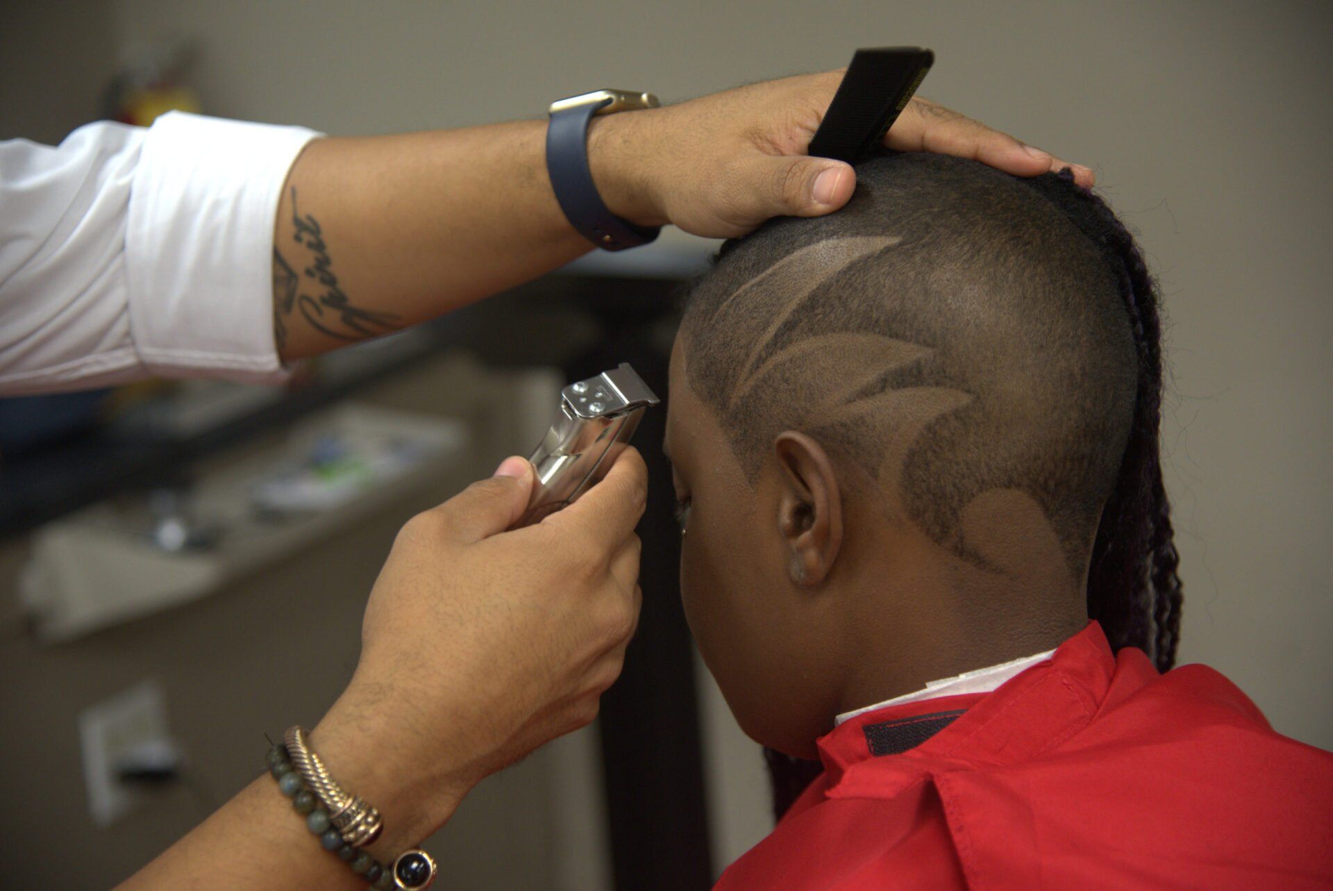 A young boy is getting his hair cut by a barber
