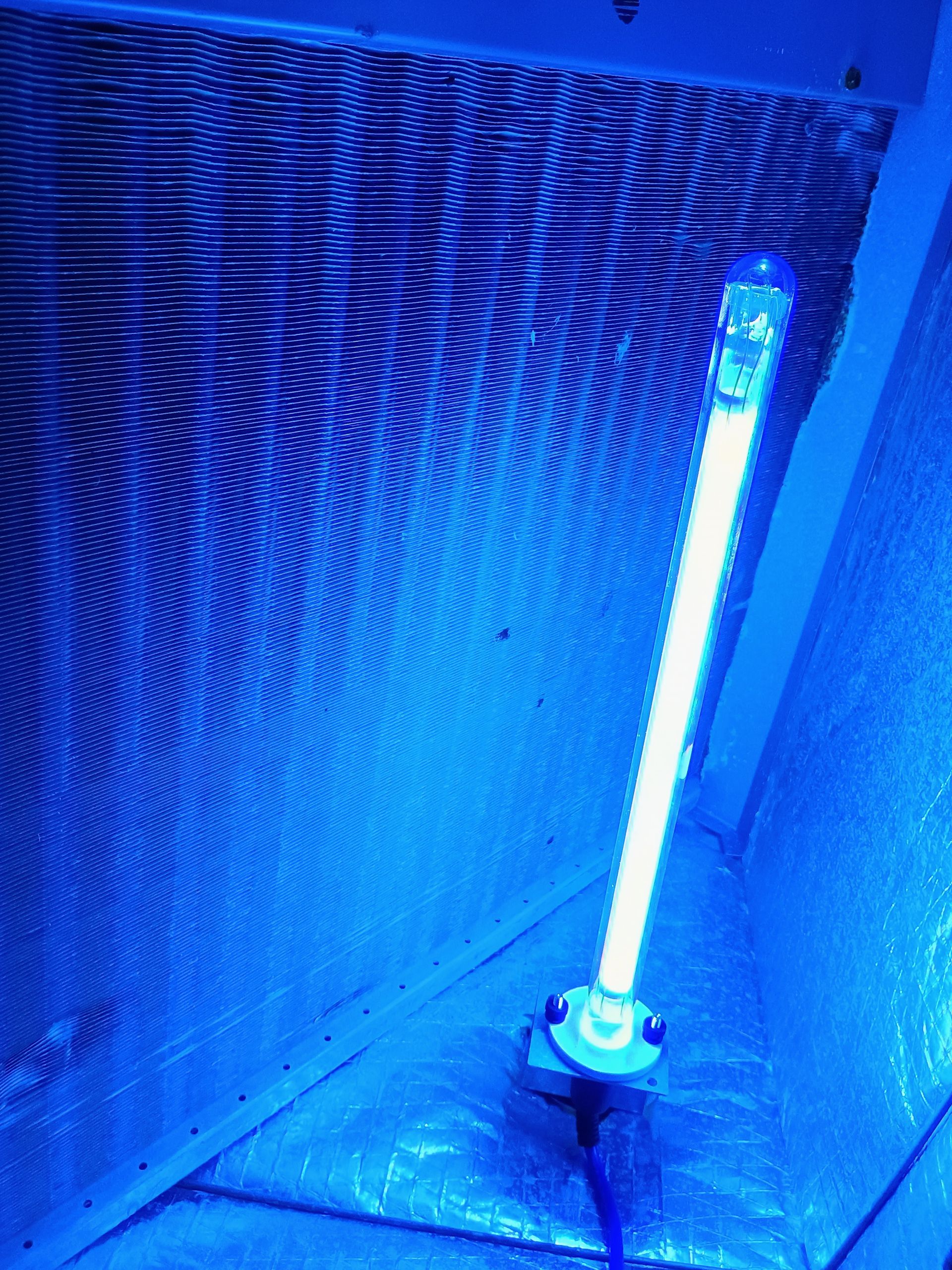 A blue UV light installed inside an air handler.