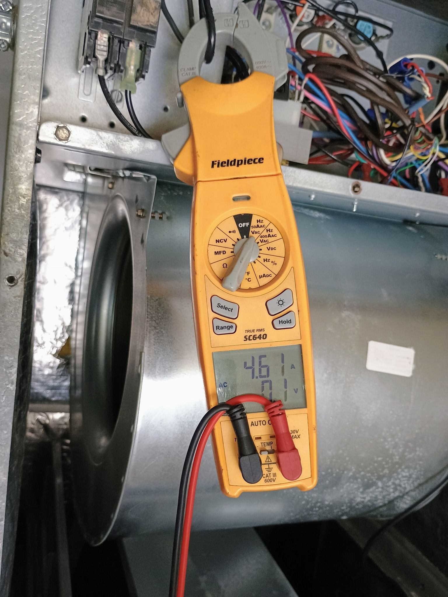 Air conditioning unit mounted above a TV, supported by yellow bracing.