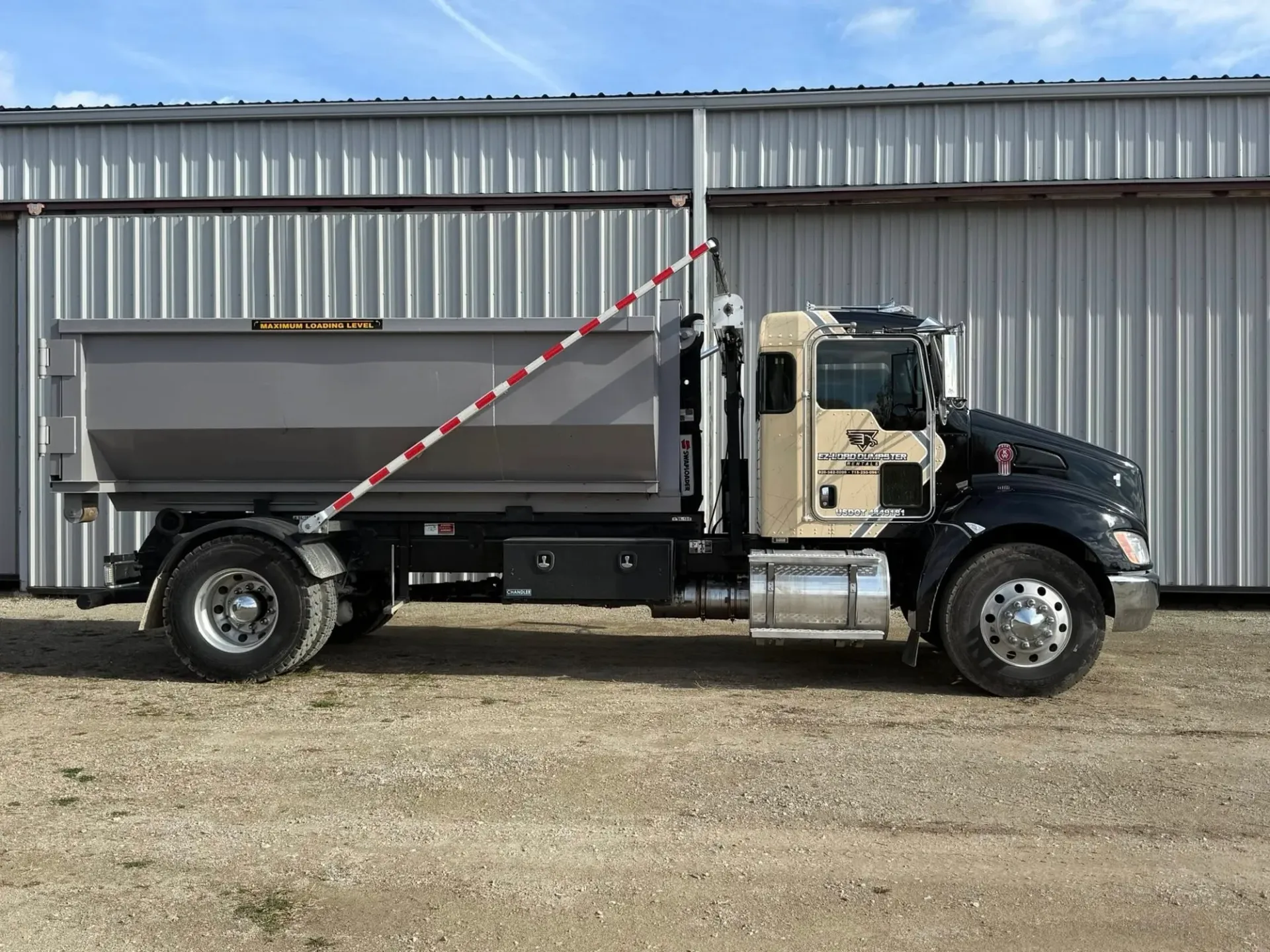 A dumpster is parked in front of a best buy store.