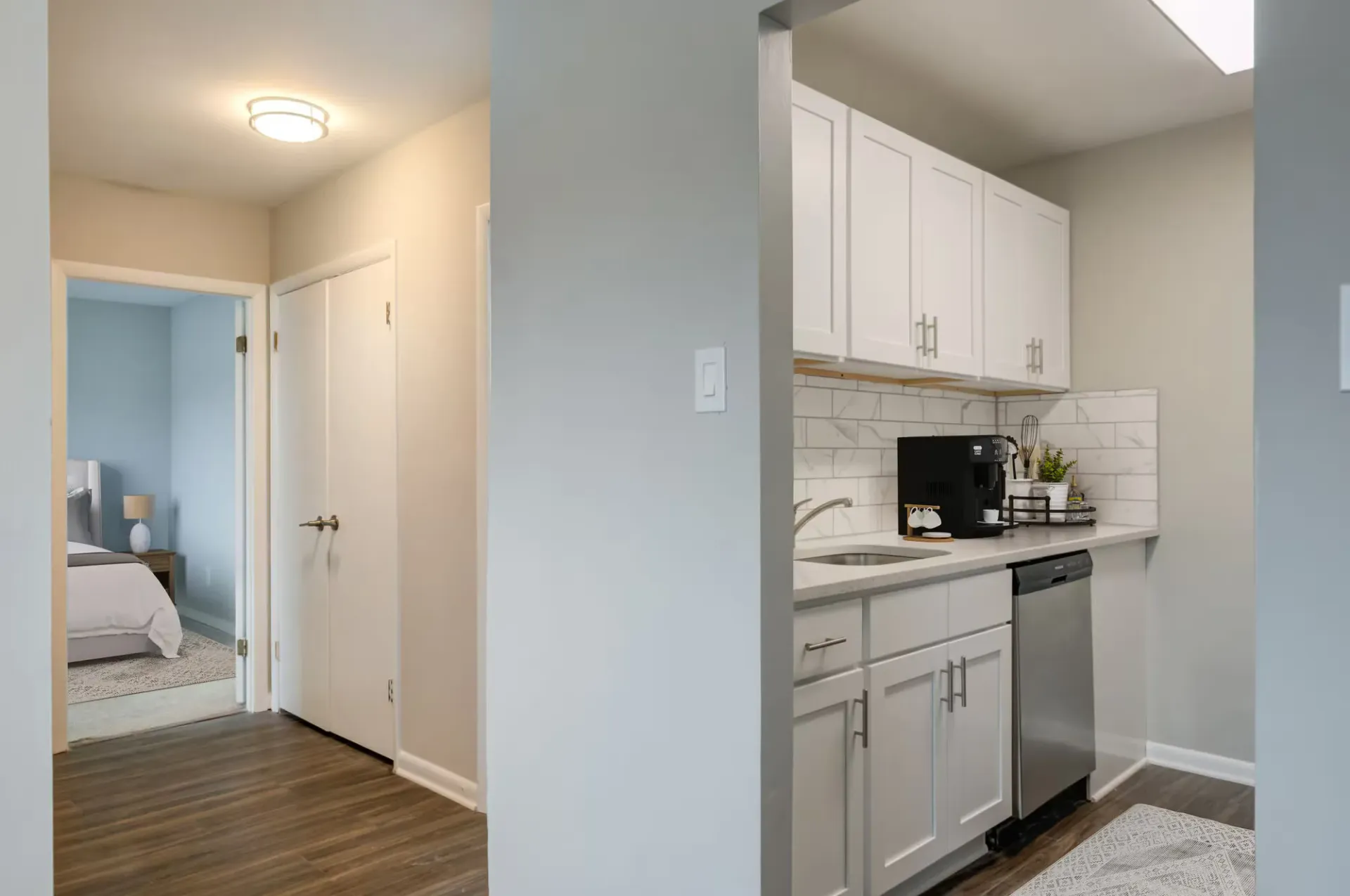 Kitchen with white cabinets, marble tile backsplash, and doorway to a bedroom hallway at The Addison, offers townhomes in North Wales, PA.
