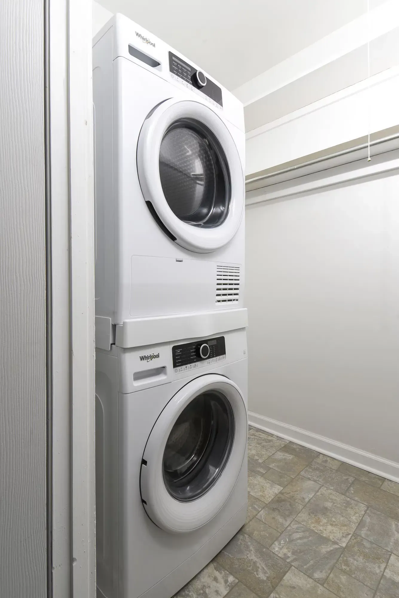 Stacked white front-loading washer and dryer in a laundry closet at The Addison, offers apartments for rent in North Wales, PA.