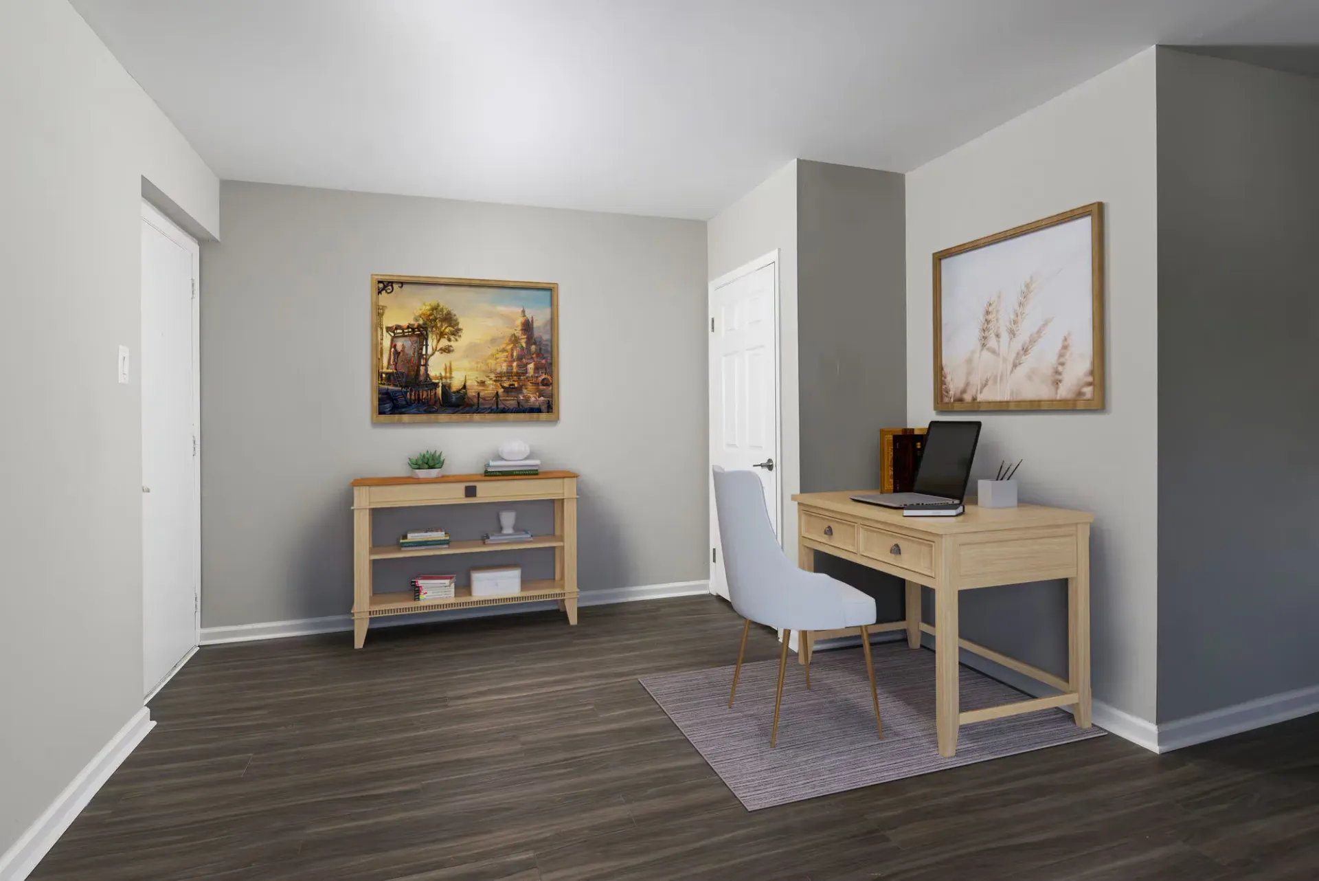 Interior home office nook with a wooden desk, chair, and wall art at The Addison, offers townhomes for rent in North Wales near Delaware Valley University.