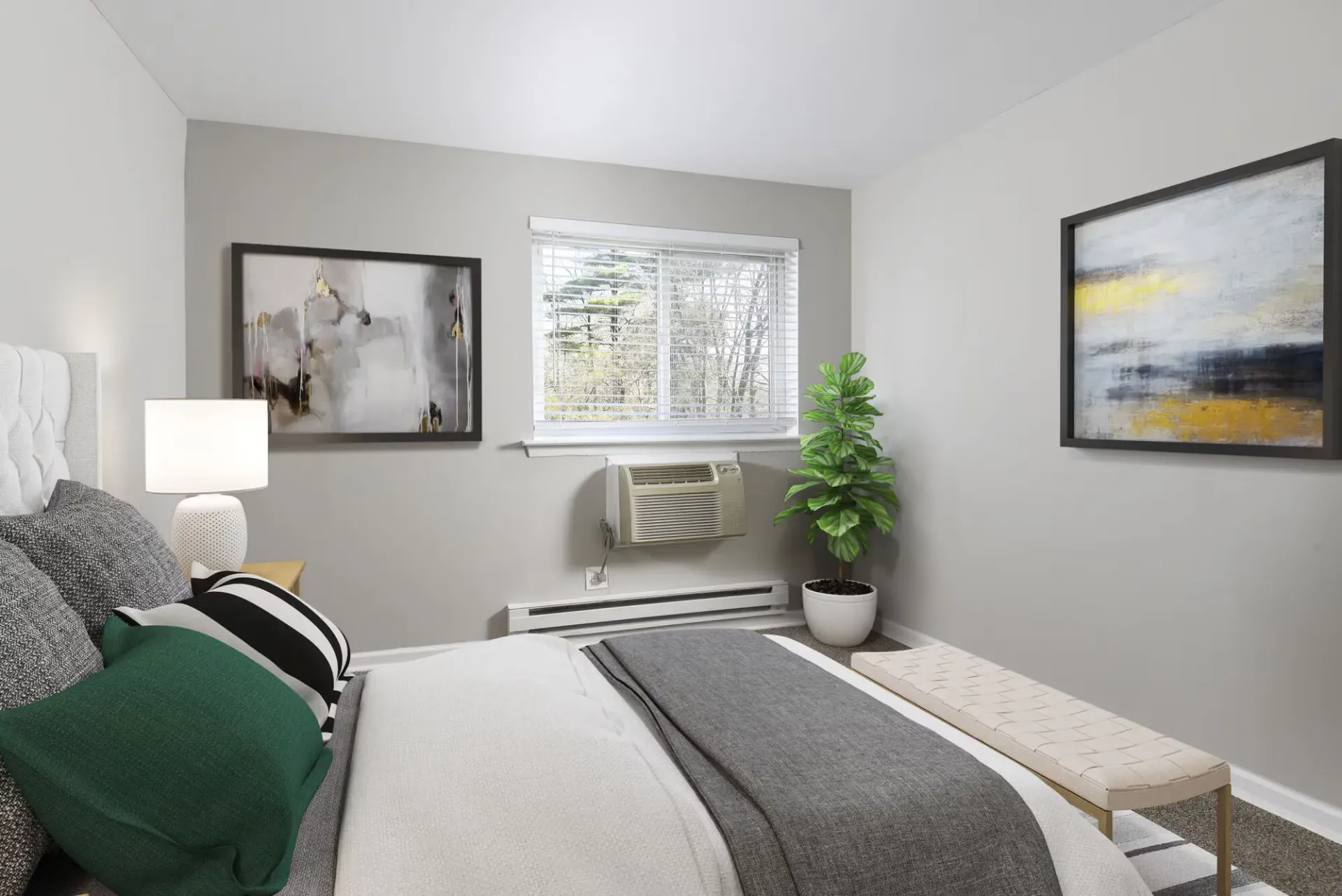 Bedroom with bed, nightstand, lamp, abstract art, window blinds, and a potted plant at The Addison, offers apartments for rent in North Wales near Gwynedd Mercy University.
