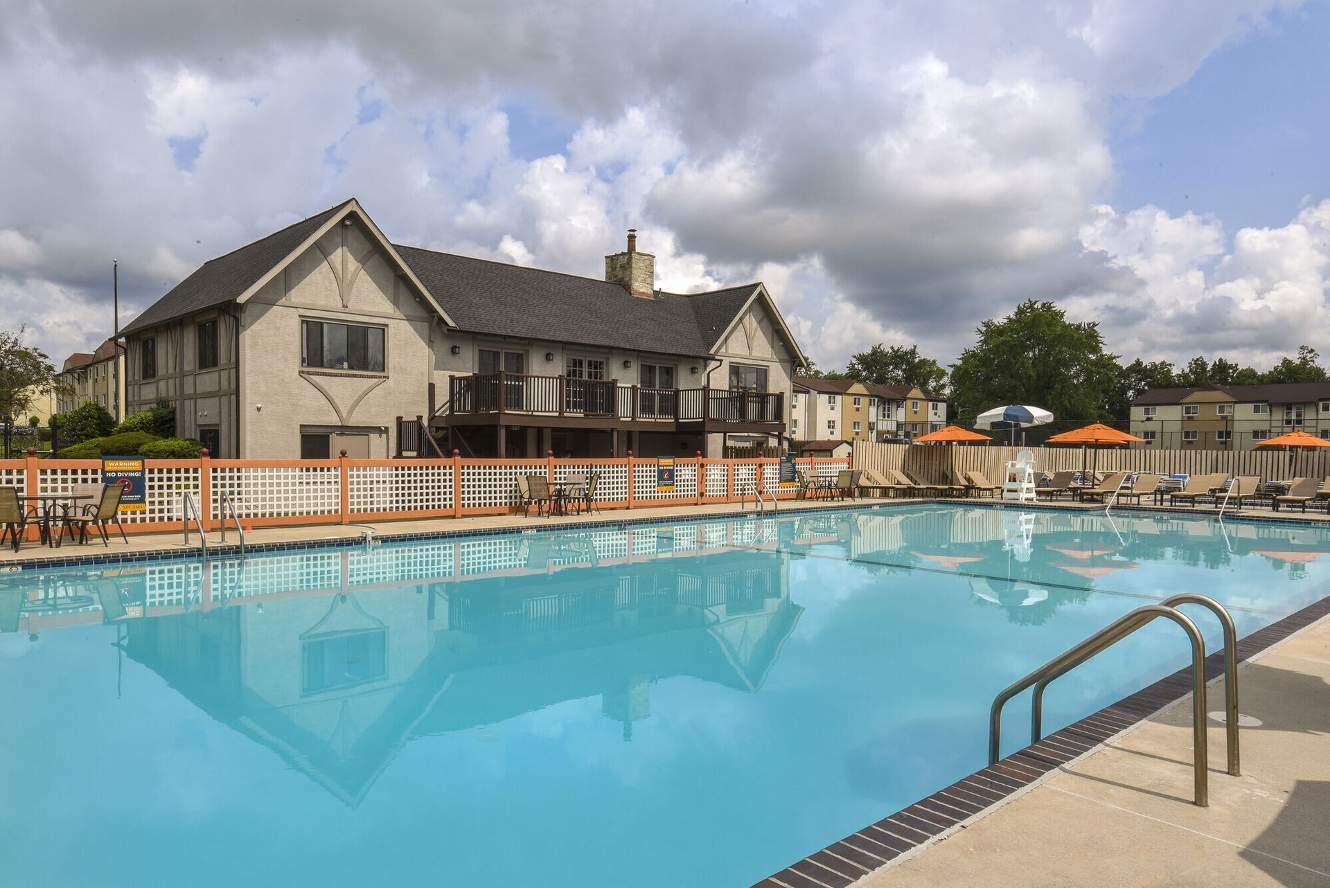 Outdoor pool at a multifamily community with lounge chairs and umbrellas at The Addison, offers apartments in North Wales, PA.