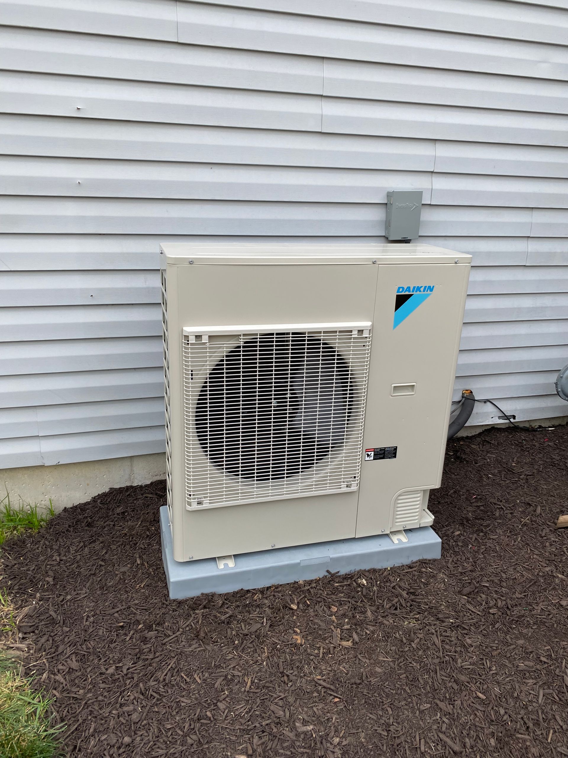 HVAC technician installing a compact and efficient Daikin Fit system in a home.