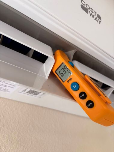 Orange Kestrel device measuring an HVAC vent at the ceiling