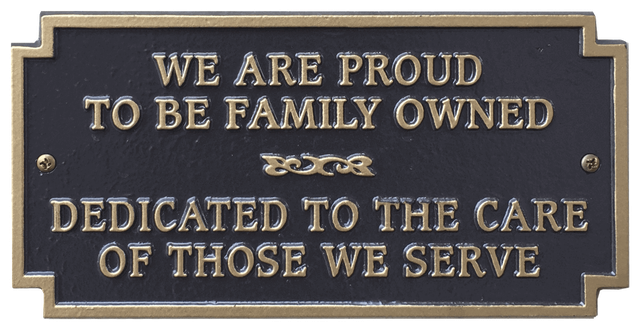 Bronze plaque with gold lettering: "We are proud to be family owned, dedicated to the care of those we serve."