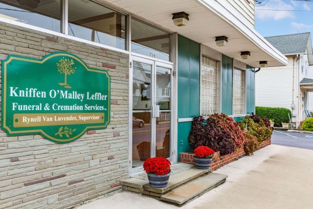 A funeral home with a green sign on the front of it