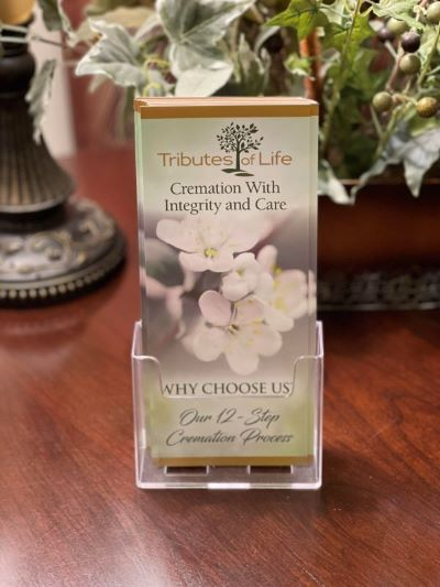 A brochure about cremation with integrity and care is sitting on a wooden table.