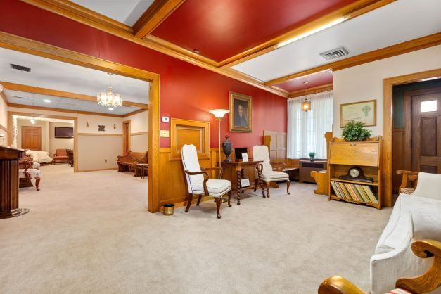 A living room with a couch , chairs , and a red ceiling.