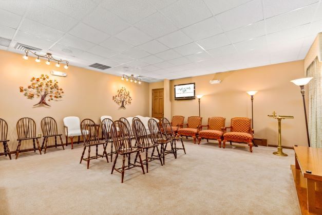 A room with a lot of chairs and a television on the wall.
