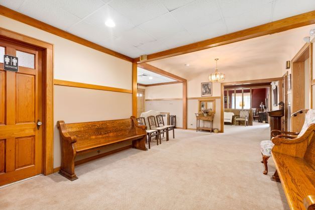 There is a wooden bench in the middle of the hallway.