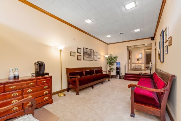 A living room with a red couch and a dresser