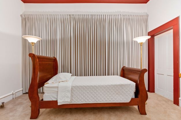 A bedroom with a sleigh bed and two lamps