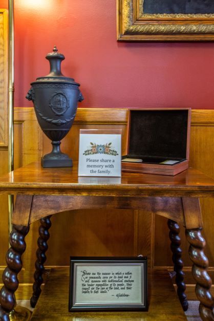 A wooden table with a vase and a box on it