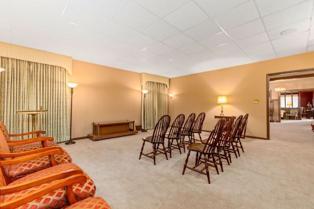 A room with a lot of chairs and a table in it.