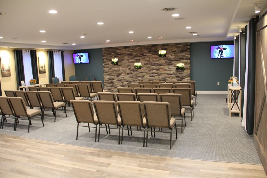 A large room with rows of chairs and a stone wall
