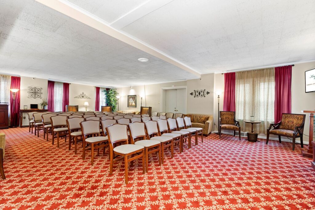 A large room with rows of chairs and a red carpet