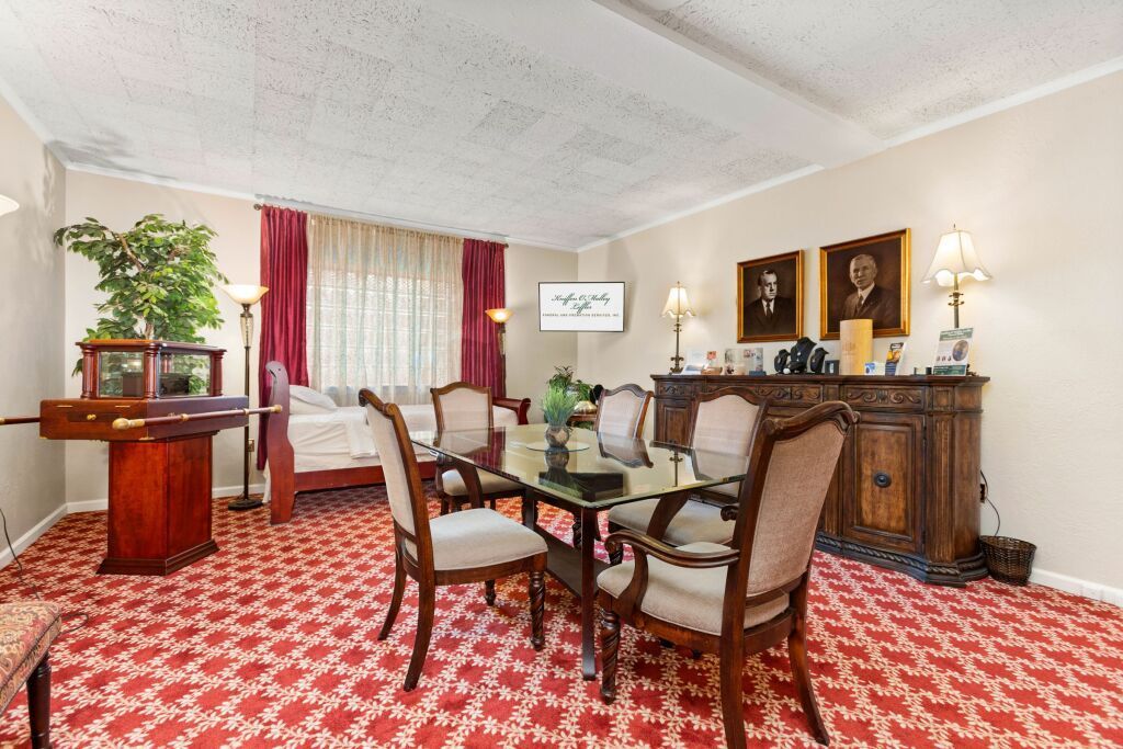 A living room with a red carpet and a table and chairs
