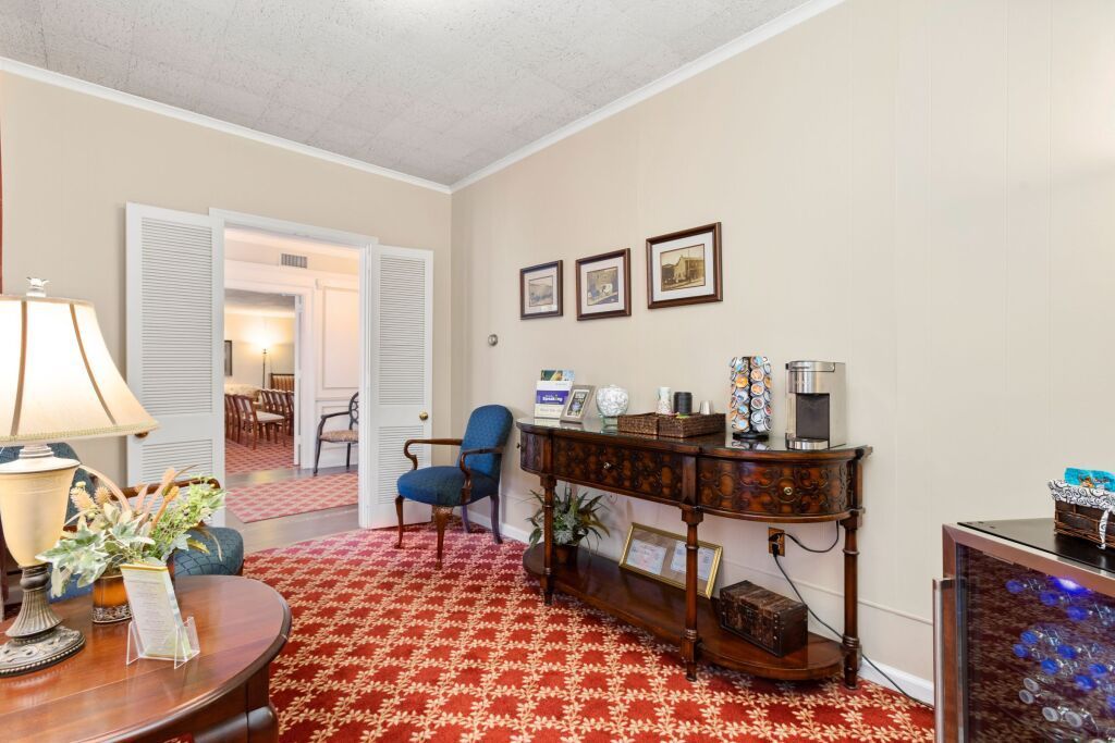 A living room with a table , chairs and a lamp