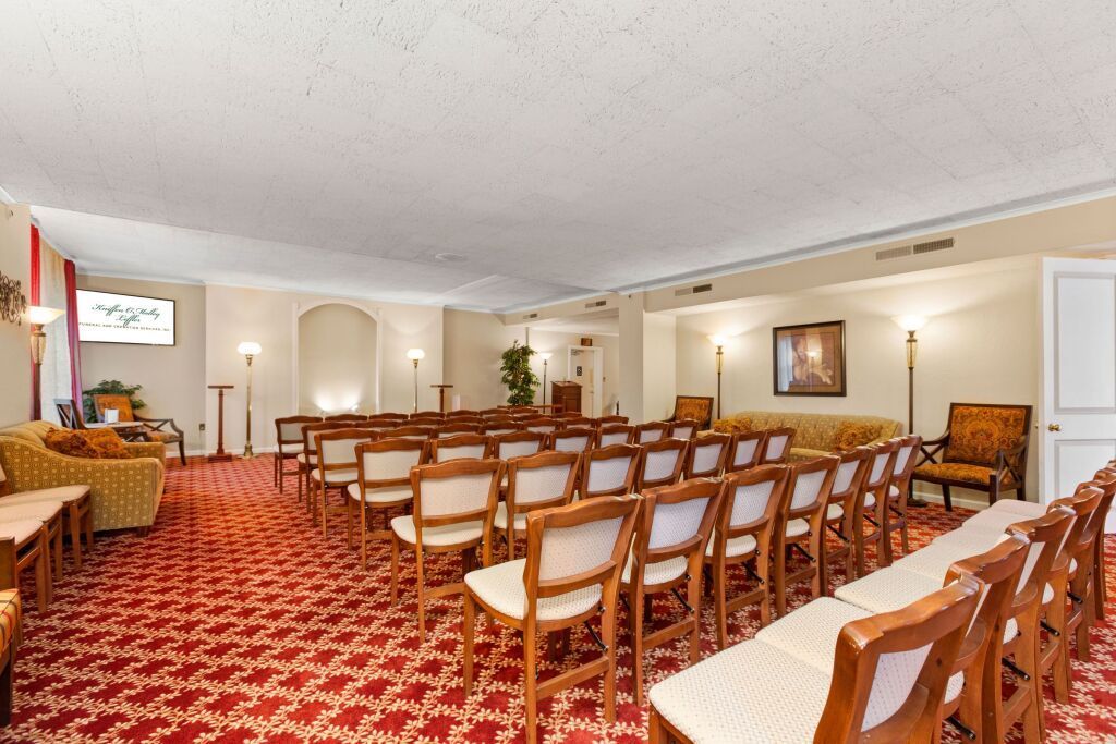 A large room with rows of chairs and a red carpet