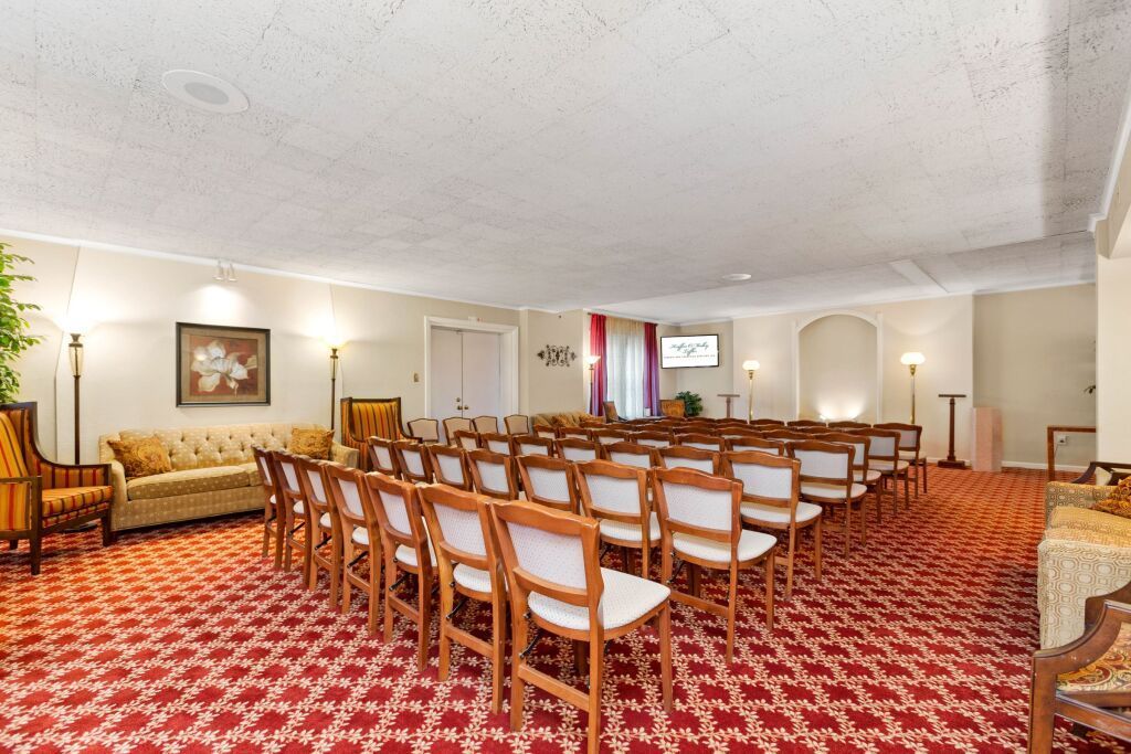 A large room with rows of chairs and a red carpet