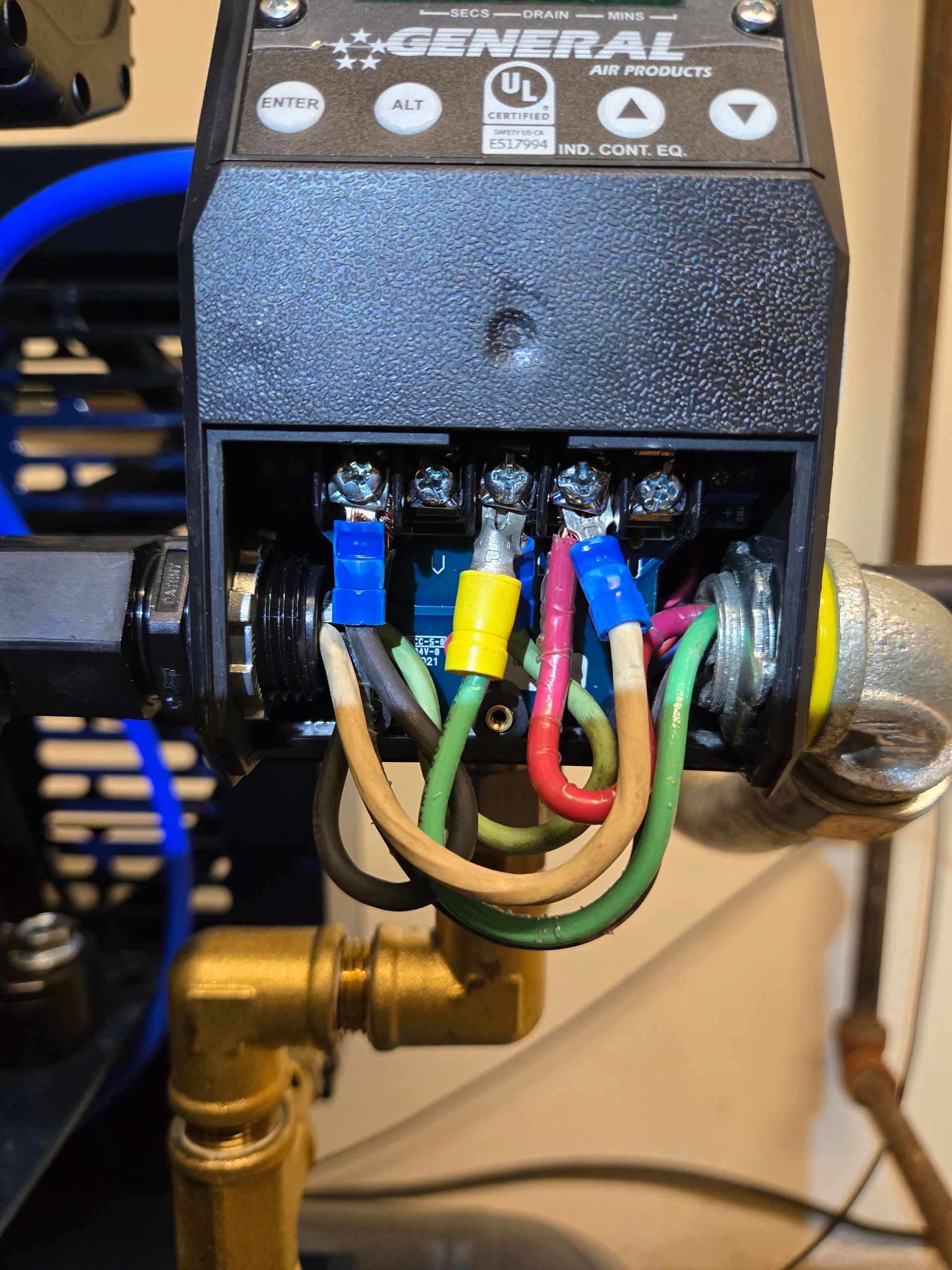 Close-up of electrical wiring connections in a black housing. Several colored wires are connected to terminals.