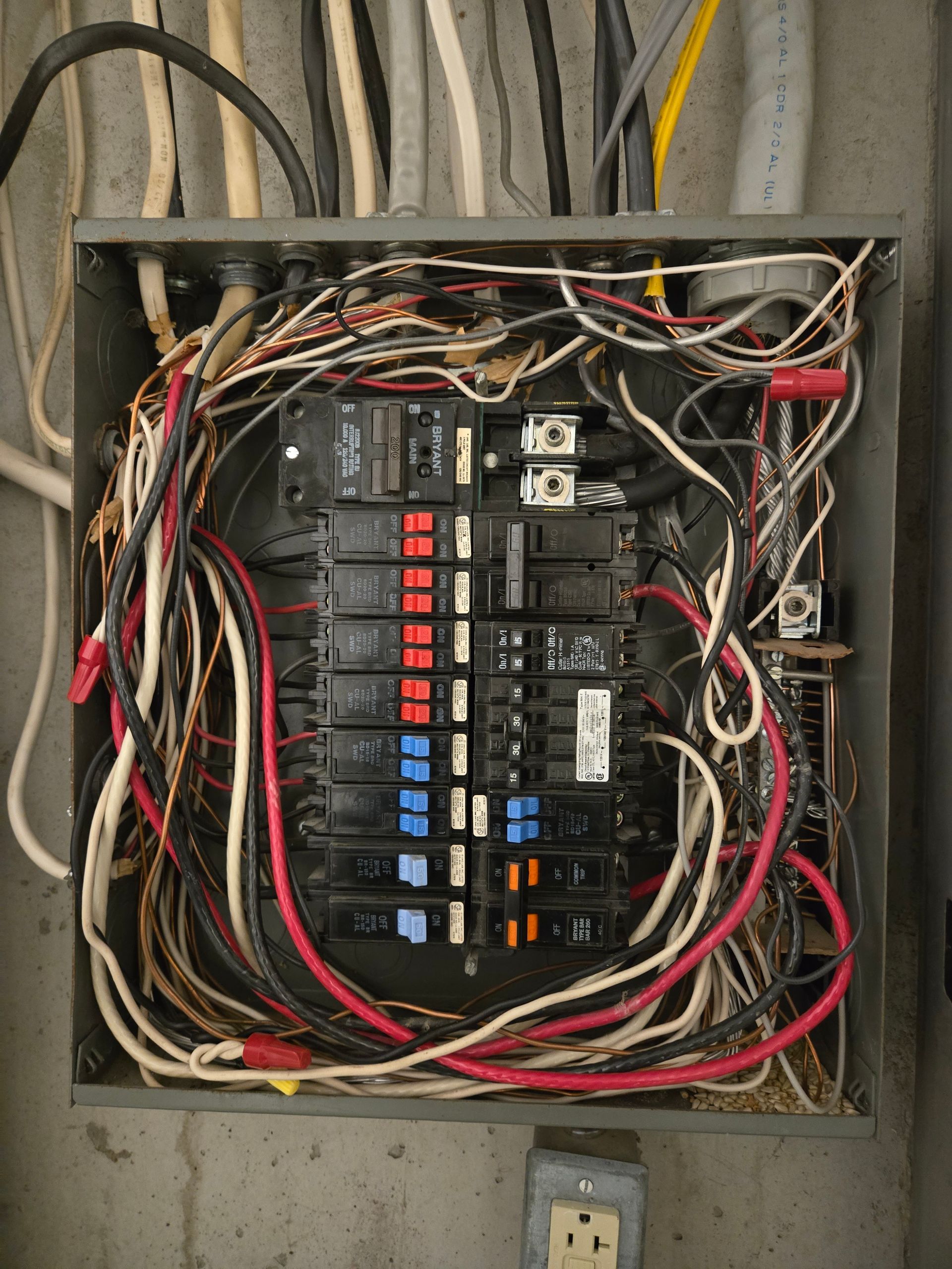 Open electrical panel with numerous wires and circuit breakers.