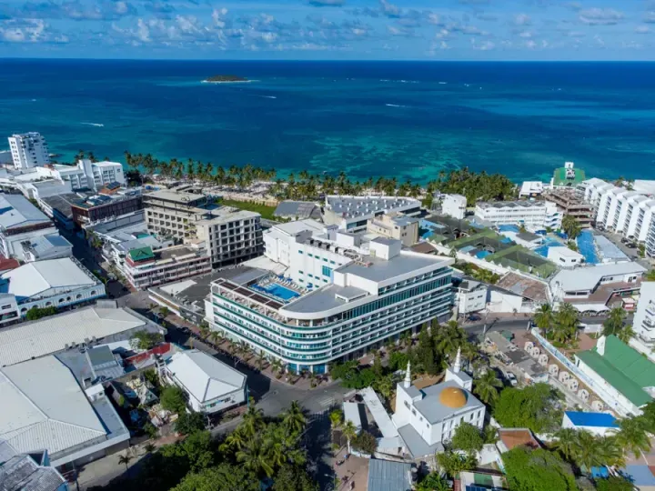 Fachada moderna del Hotel Aquamare en San Andrés, arquitectura contemporánea con amplios ventanales y terraza con vista al mar de los siete colores en la isla.