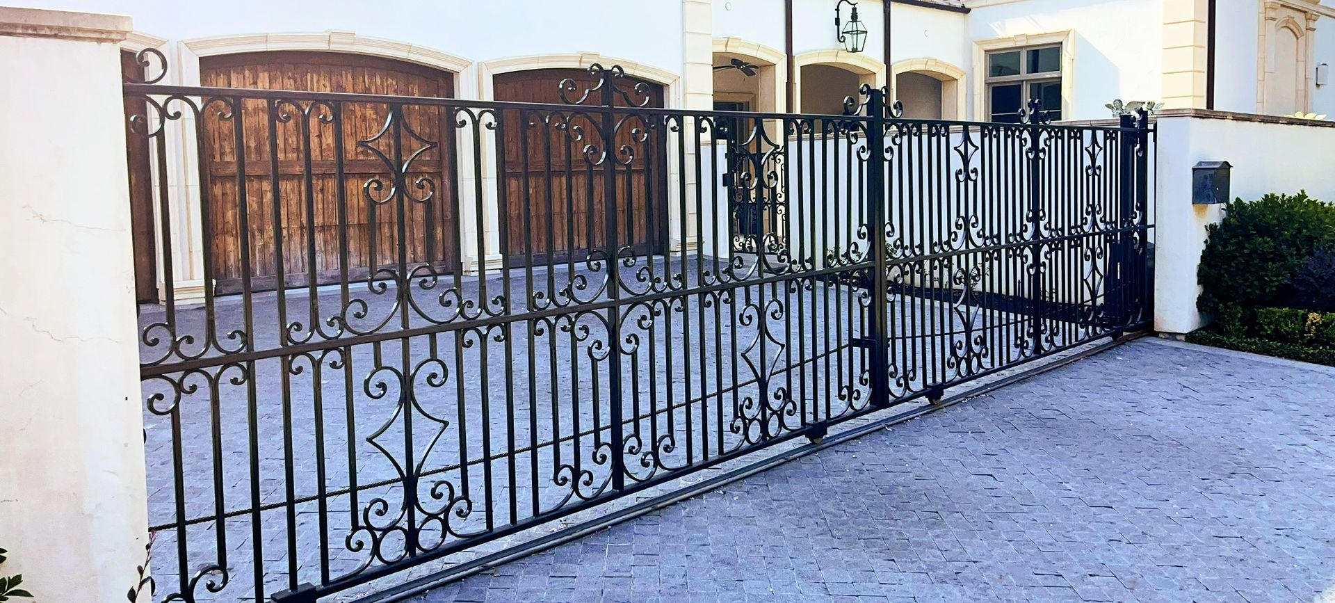 A custom decorative ironworks gate on a driveway