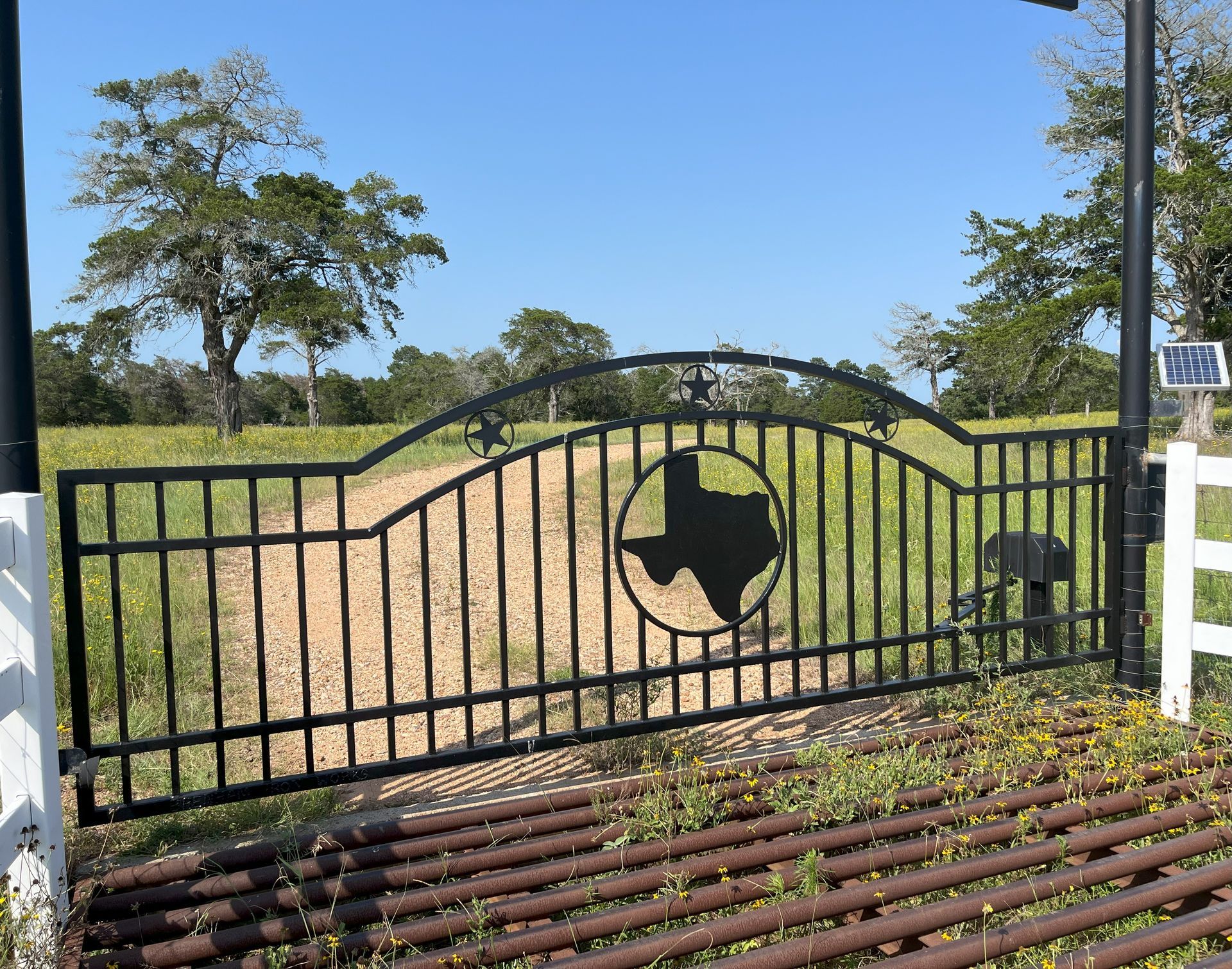 A custom entrance gate made with wrought iron at a ranch near Waco, Texas