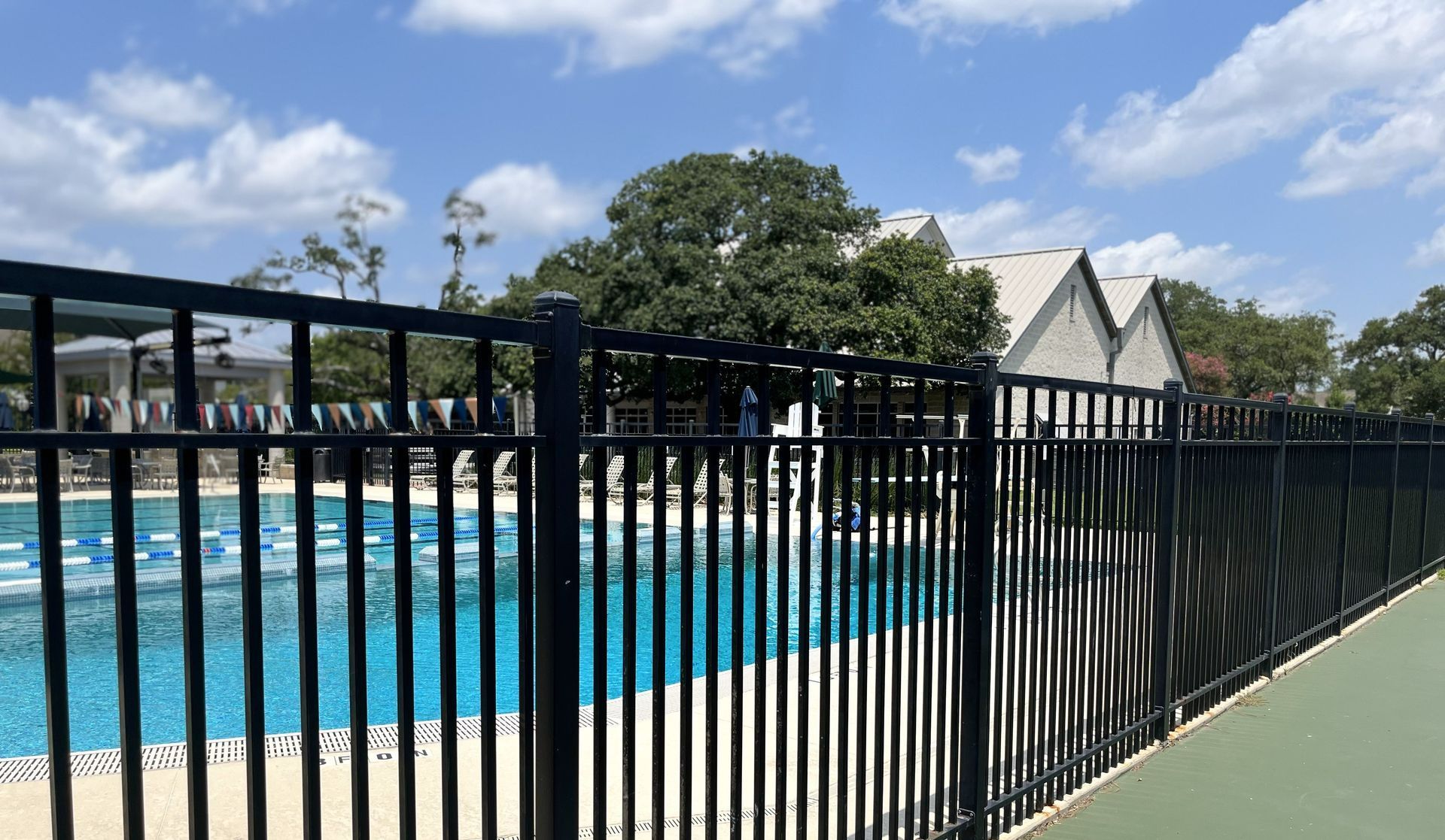 A tall wrought iron safety fence protecting a swimming pool