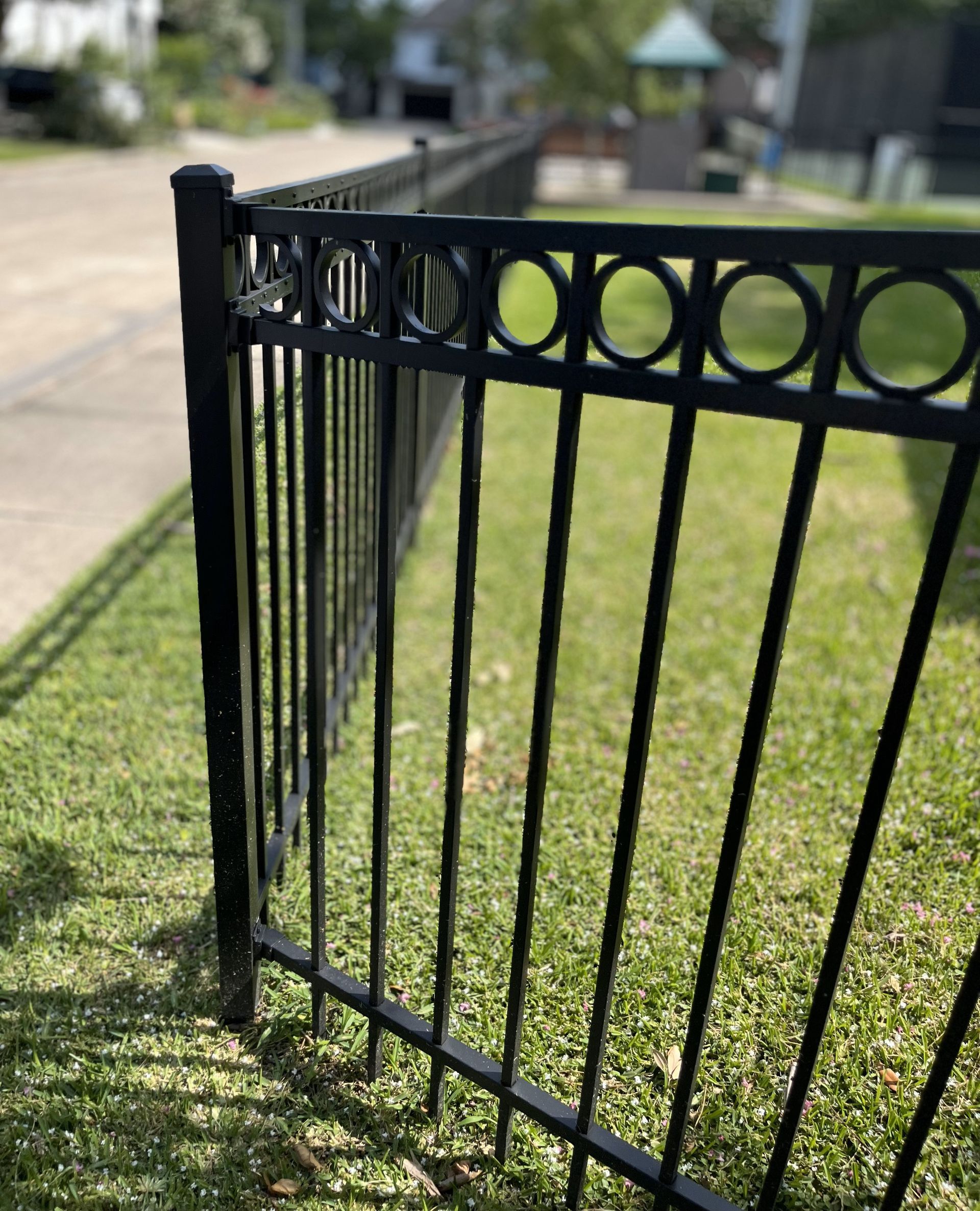 A wrought iron fence with decorative features at a home