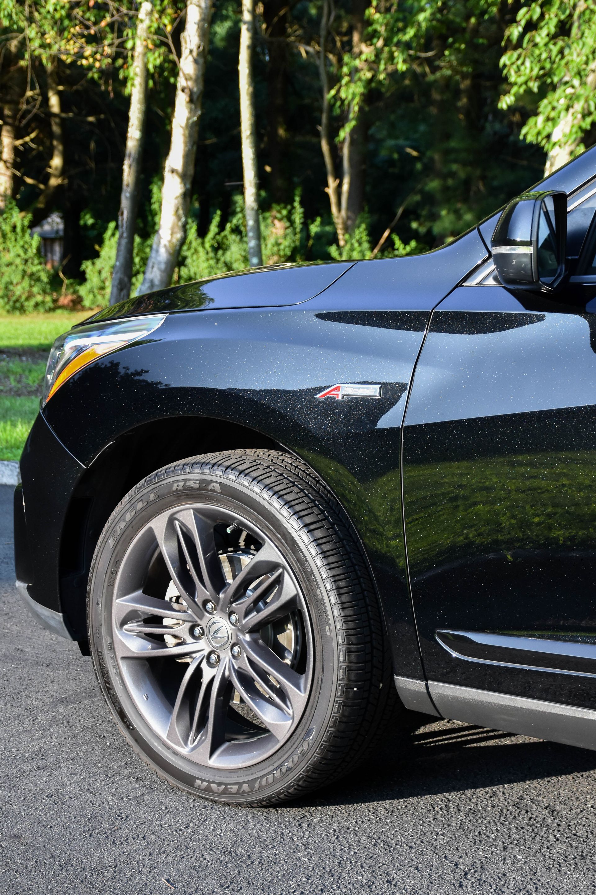a person wearing black gloves is polishing the hood of a car .