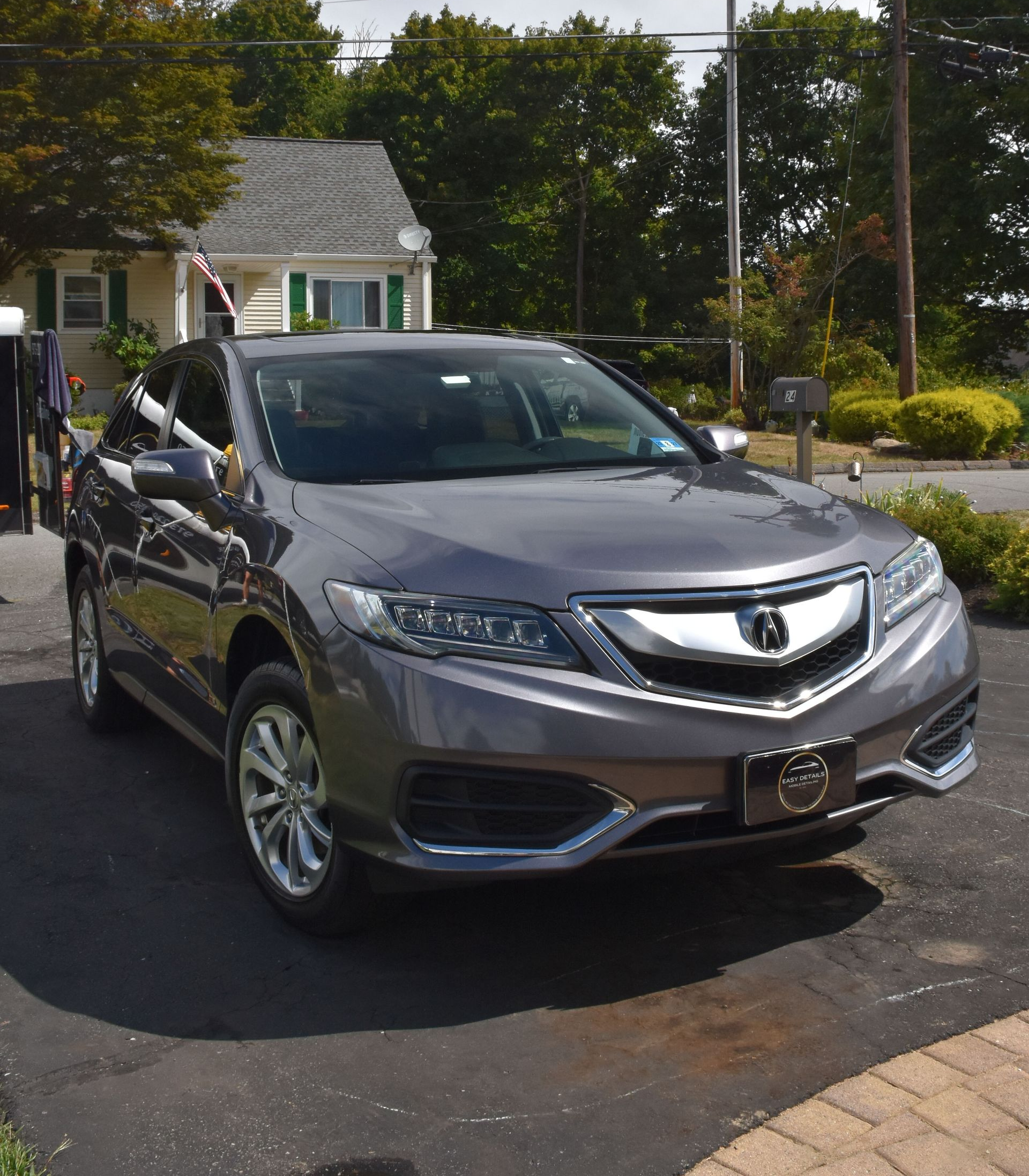 a person is polishing the hood of a blue car .