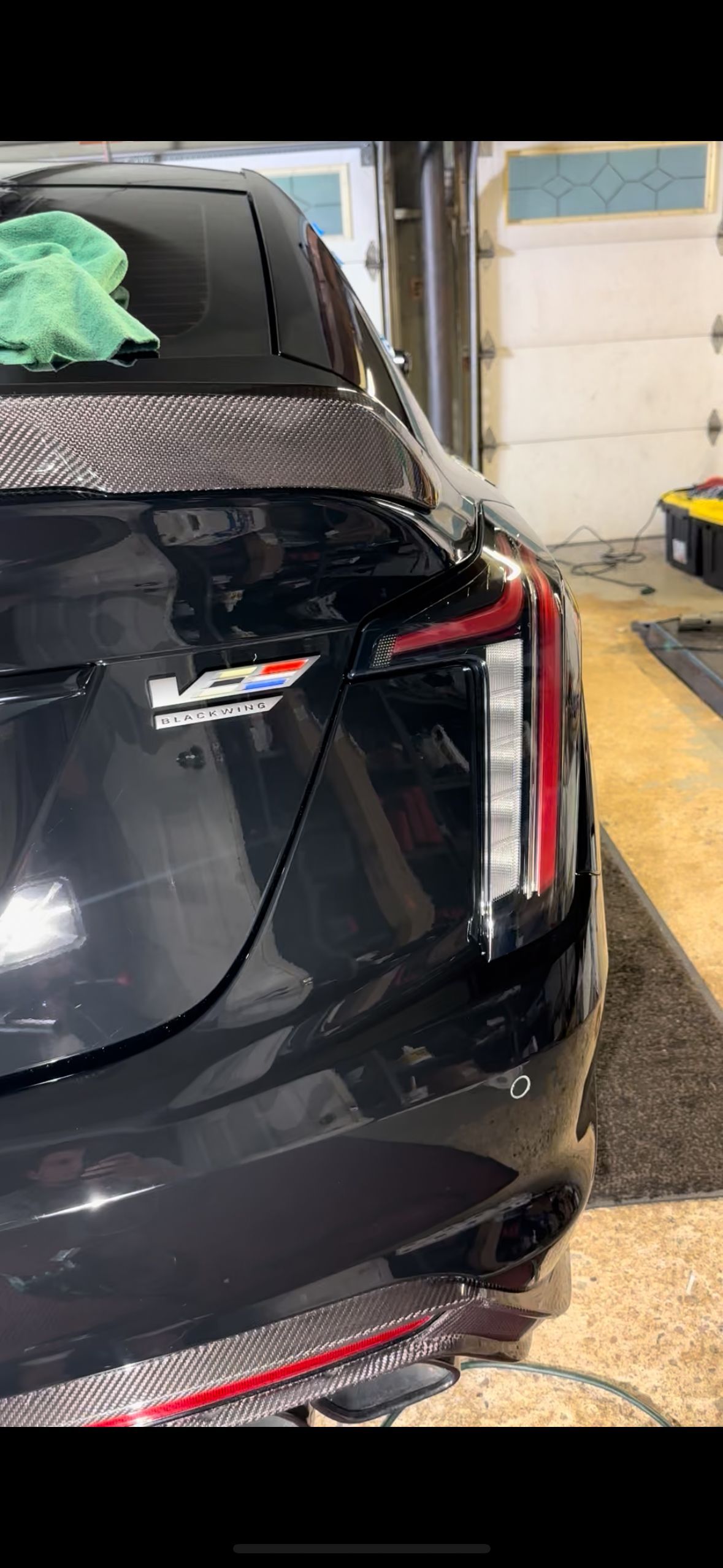 Black Cadillac CT5-V rear with a V logo and red accents, parked indoors.