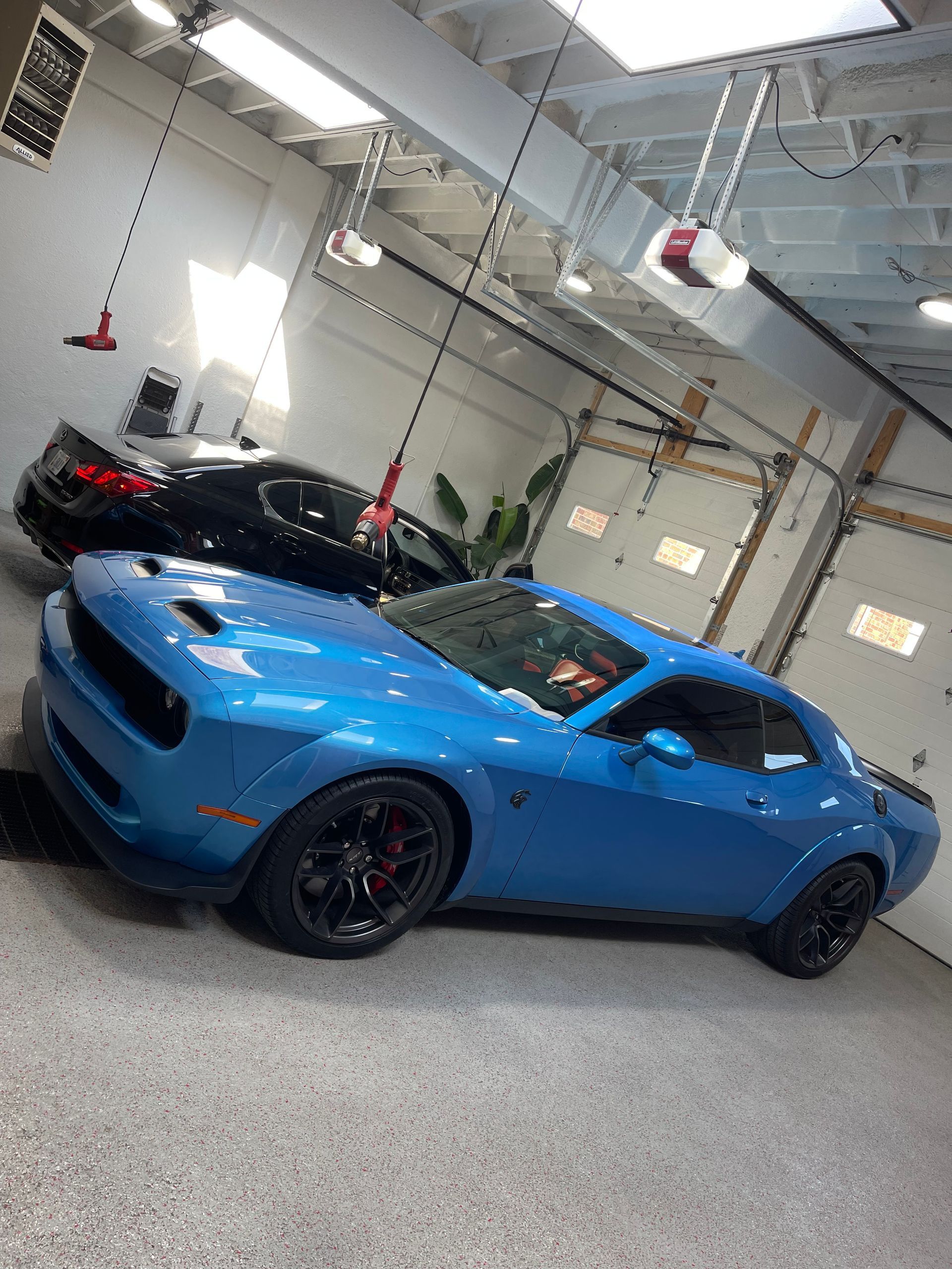 Rear view of silver Mustang car with iconic red tail lights, outdoors at dusk.